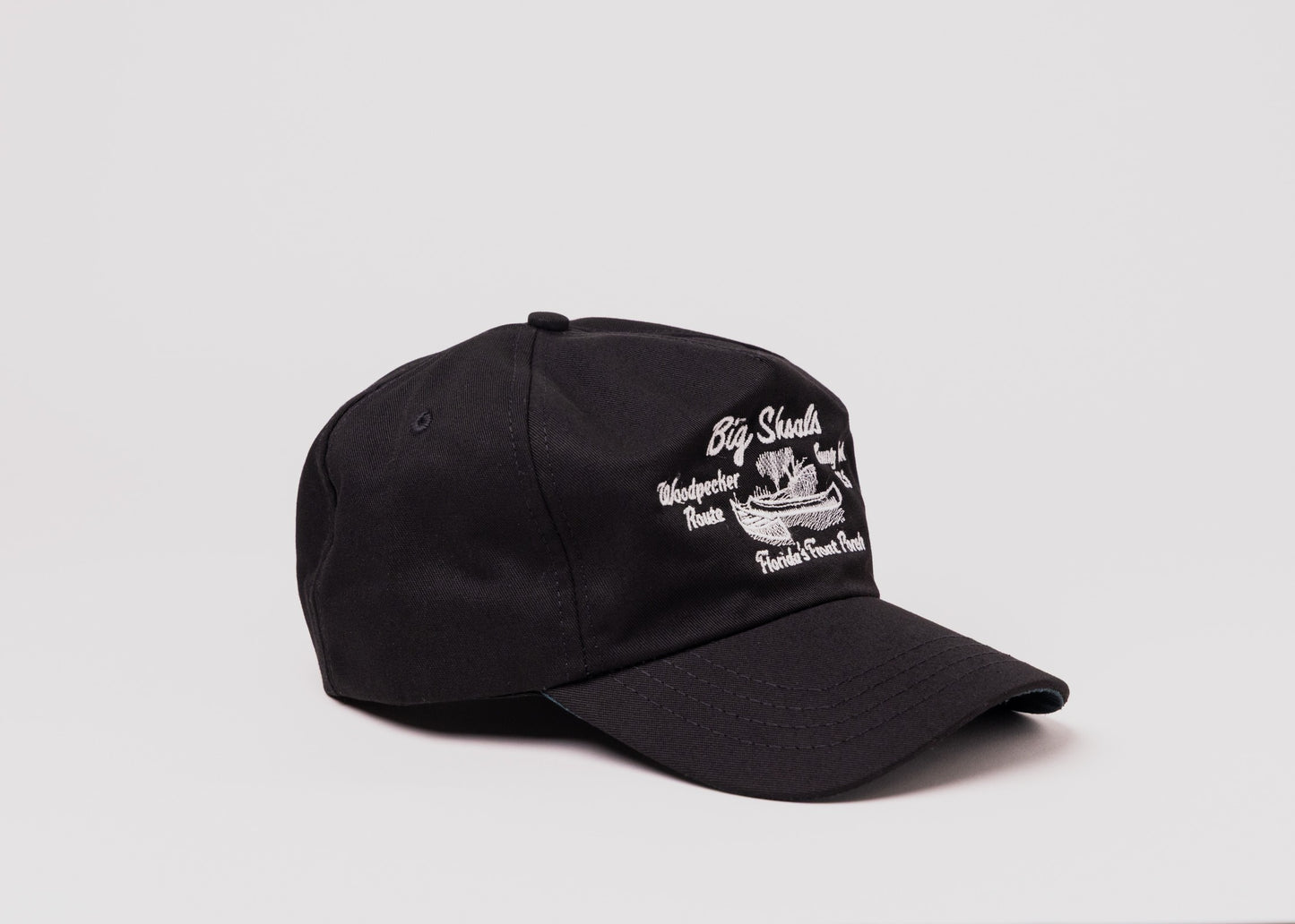 Black Besco hat with white embroidered ‘Big Shoals’ and canoe design, angled front view on white background.