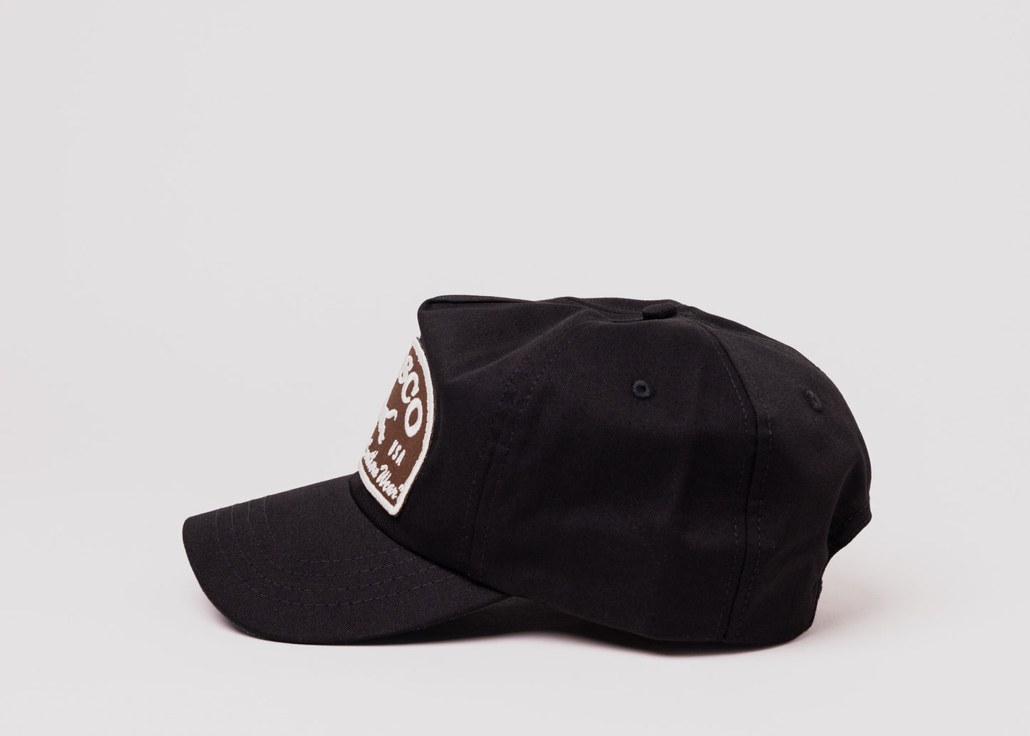 Black Besco hat with brown and white embroidered fox patch, side profile on white background.