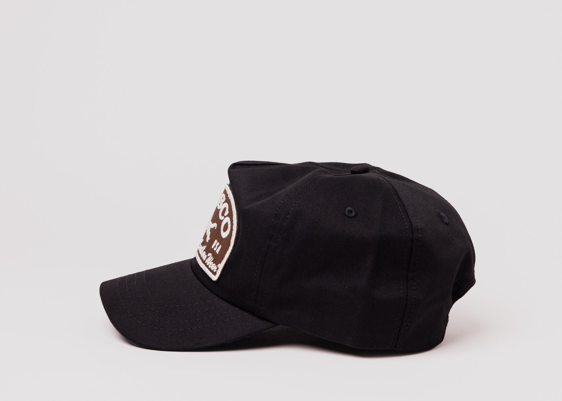 Black Besco hat with brown and white embroidered fox patch, side profile on white background.