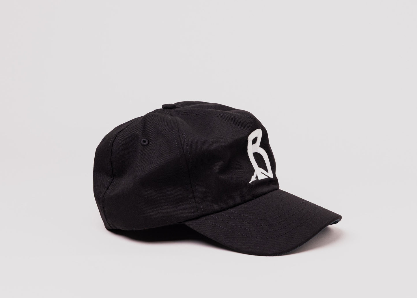 Black Besco hat with white embroidered letter 'B’ design, angled front view on white background.