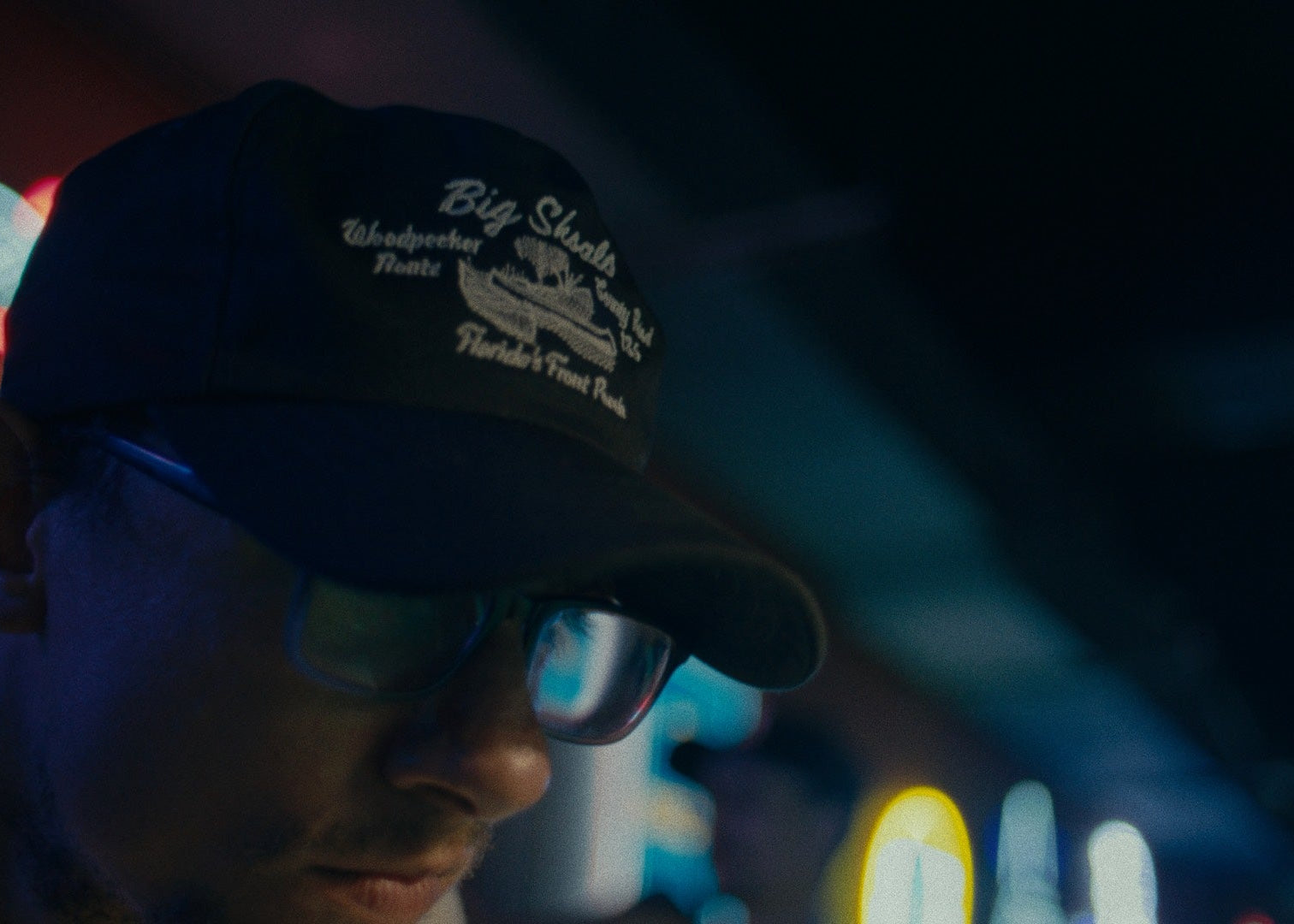 Close-up shot of a man wearing a Besco “Big Shoals” "Suwannee River" hat in a bar setting the Besco Release 1 shoot.