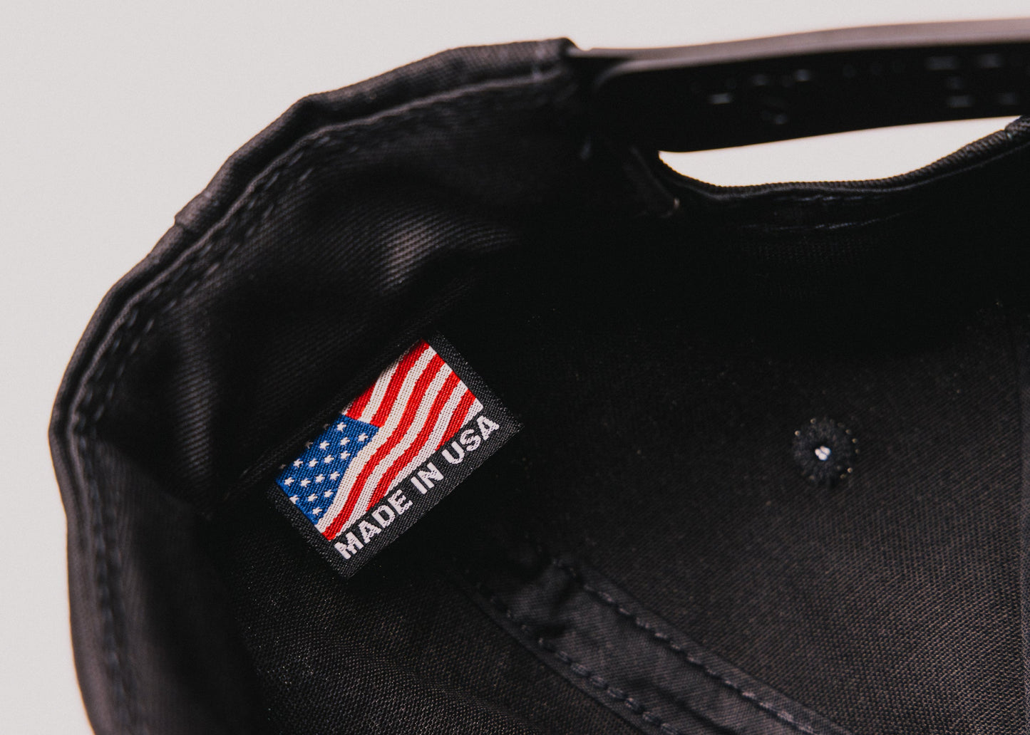 Close-up of black Besco hat interior showing ‘Made in USA’ tag with American flag label.